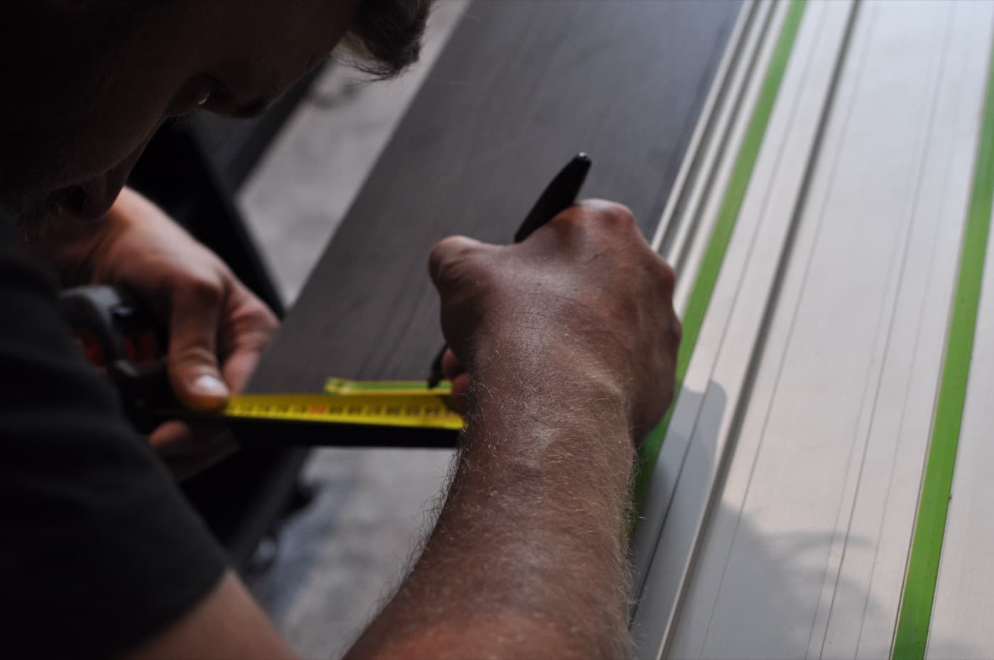 Marking out a panel with a tape measure before cutting