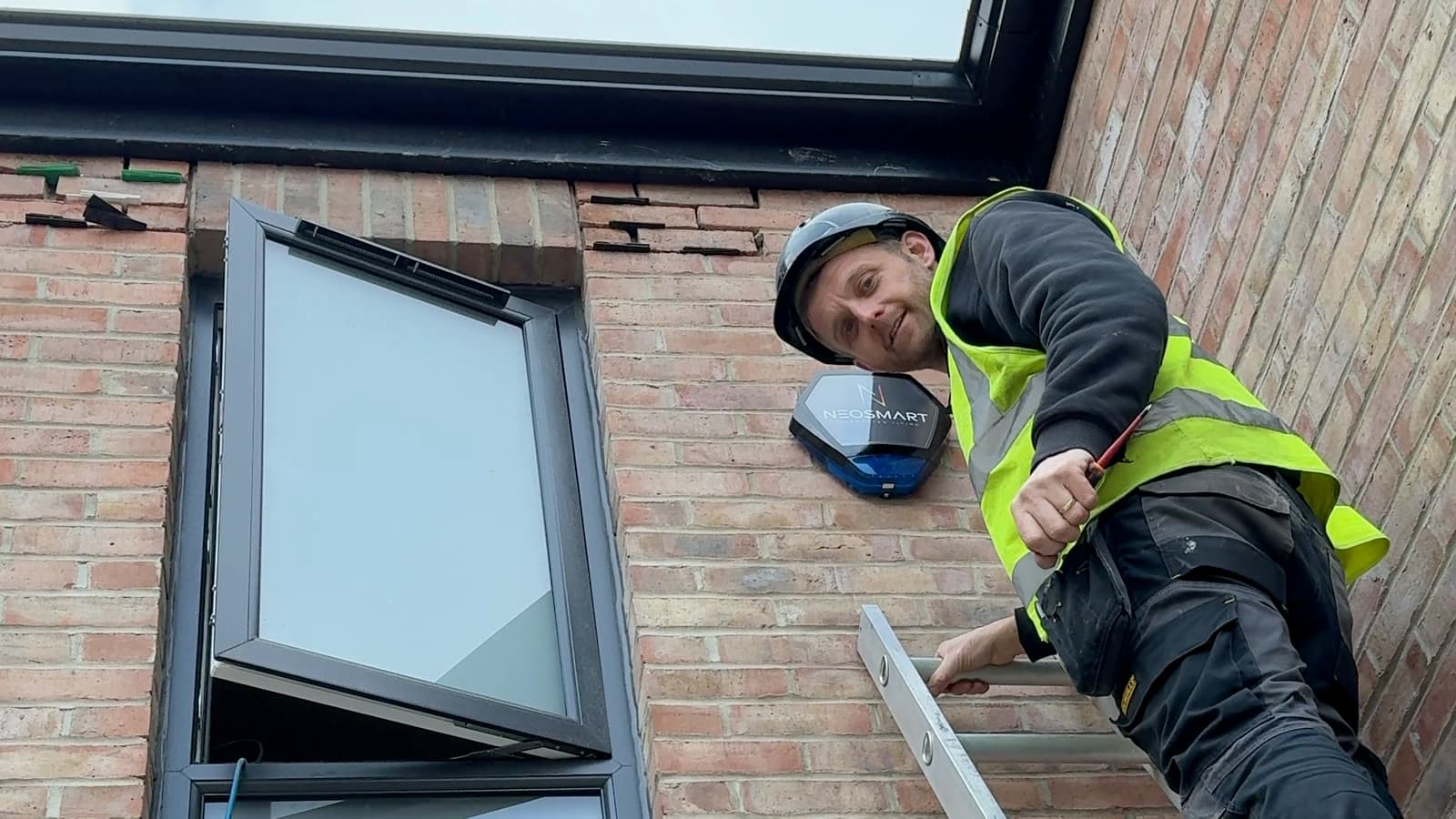 A Neosmart engineer on a ladder fitting external security equipment