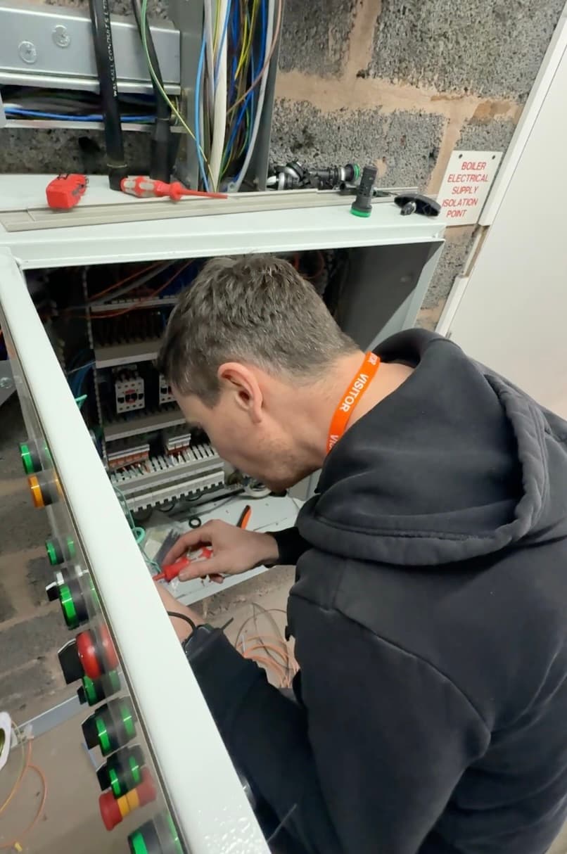 A Neosmart engineer working inside a commercial building-control panel